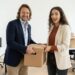 Lia startet mit einem Umzugskarton im neuen Büro, Maik hilft